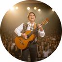 Guitarrista folklórico sobre un escenario, sosteniendo una guitarra criolla con luz cálida y público de fondo